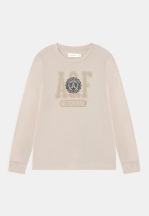 Camiseta beige de manga larga para niños con cuello redondo, que presenta el logo "AQF" y "Abercrombie New York" en el centro del pecho.