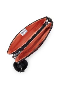 Svart tygpåse med orange interiör; har två fack med dragkedja och en svart pom-pom som accent. Märkt inuti med "Kipling".