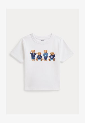 T-shirt blanc à manches courtes avec quatre ours en peluche portant des pulls bleus, chaque pull affichant une lettre formant le mot "POLO" sur la poitrine.