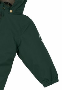 Jachetă verde cu glugă, de textură netedă, prevăzută cu închidere cu fermoar și manșete elastice. Mâneca stângă are un detaliu subtil reflectorizant sub forma unui logo.