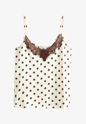 Kremfarvet camisole med brune polkaprikkker og brun blonderkant langs V-udskæringen og tynde skulderstropper.