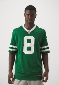 Žalia futbolo marškinėliai iš audinio, su baltu numeriu 8 ir baltais raštais ant rankovių. Ant apykaklės yra NFL logotipas.