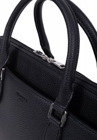 Sac à main en cuir noir avec une surface texturée, deux poignées supérieures et une fermeture éclair en métal argenté. Présente une fermeture éclair ouverte pour accéder à l'espace intérieur.