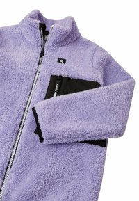 Giacca in pile viola con colletto alto, chiusura a zip e dettagli neri nelle tasche. Presenta un tessuto testurizzato e accenti a contrasto.