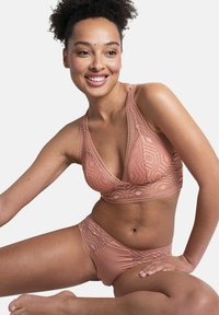 Soutien-gorge rose clair et culotte assortie ornés de motifs en dentelle géométrique, avec une texture douce et des détails de bande confortable.