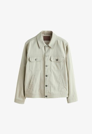 Lyse beige denimjakke med krave, to brystlommer og sidelommer. Har metal knapper og et tekstureret stof. Standard pasform.