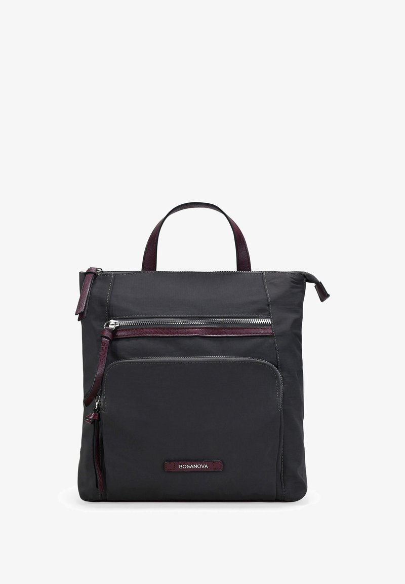 Bolsa de nylon negra con dos bolsillos frontales con cremallera, detalles en cuero en color burdeos, asa superior y parche con el logo en la parte inferior. Forma cuadrada con detalles de costura.