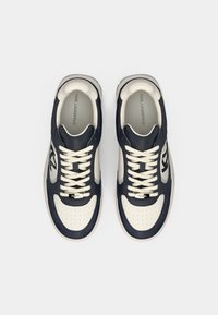 Ναυτικά μπλε και κρεμ δερμάτινα αθλητικά παπούτσια με κούμπωμα με κορδόνια, διάτρητη μύτη, επενδυμένο πέλμα και λογότυπο στην πλευρά και στη γλώσσα.