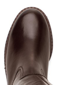 Botín de cuero marrón con acabado brillante, puntera redonda y costuras decorativas a lo largo del lateral. Suela de goma texturizada visible.