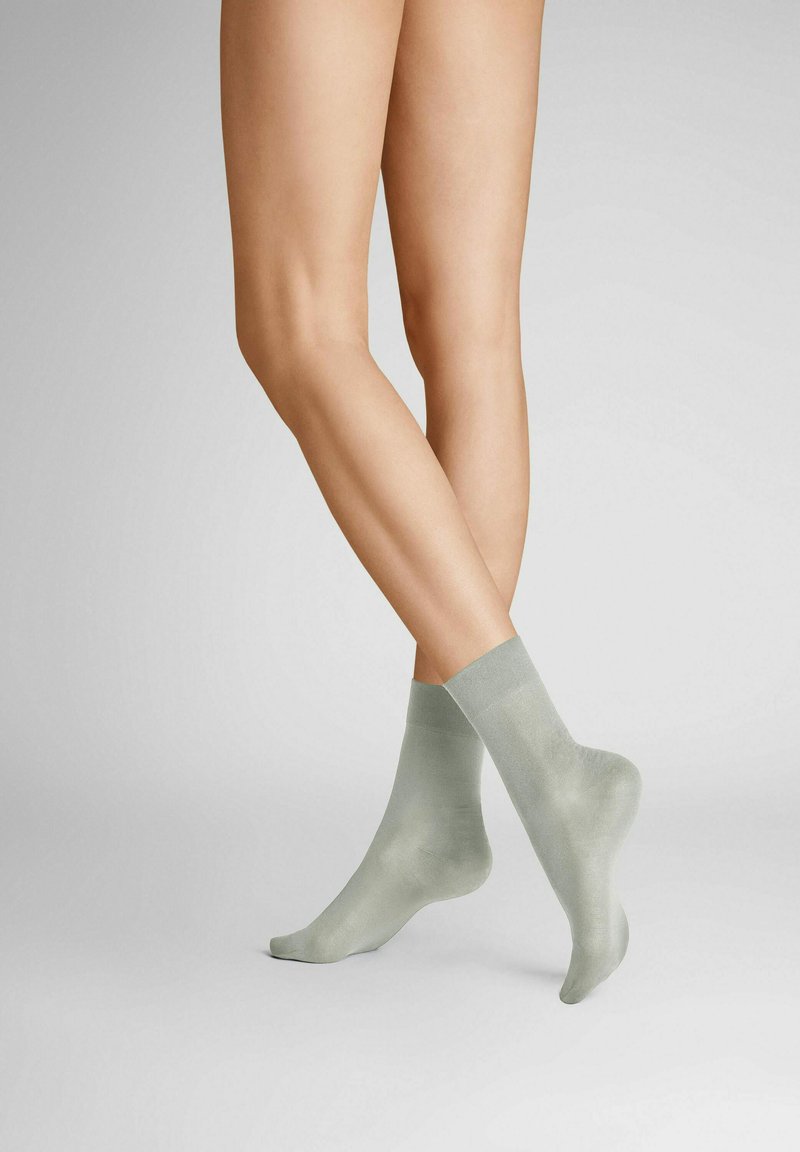 Light green ankle socks made of a smooth, slightly shiny material, with a simple design and ribbed cuff detailing.