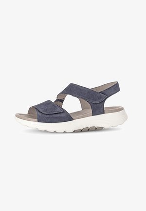Navy blue suede sandals with open toe design, cross straps, and adjustable back strap. Features a cushioned white rubber sole.