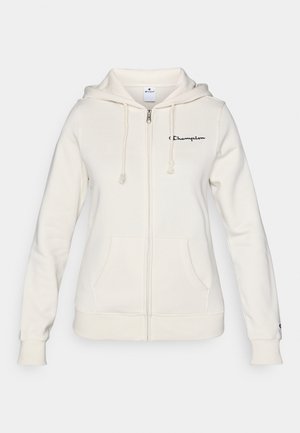White zip-up hoodie made of soft fabric, featuring a drawstring hood, front pockets, and a small logo on the left chest.