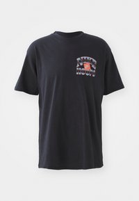 Czarny bawełniany t-shirt z grafiką "NIKE HOOPS" w kolorach czerwonym i białym. Klasyczny okrągły dekolt i krótkie rękawy. Miękka faktura, luźny krój.