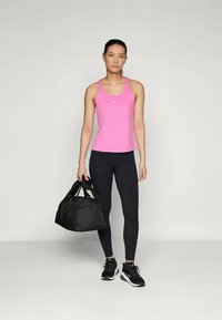 Idrettsantrekk med en tettsittende rosa tanktop, svarte leggings og svarte joggesko, med en svart treningsbag i hånden. Enkelt og funksjonelt design.