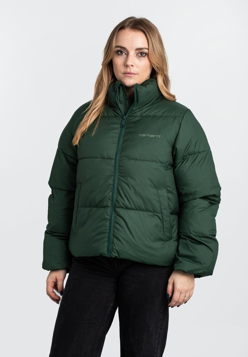 Giacca puffa verde scuro con colletto alto, chiusura a zip e tasche laterali. Presenta sezioni trapuntate per isolamento e durata.