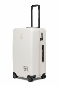Weißer Hartschalenkoffer mit einem ausziehbaren schwarzen Griff, vier schwarzen Rädern, einem pinken Reißverschluss und einem diamantförmigen Logo auf der Vorderseite.