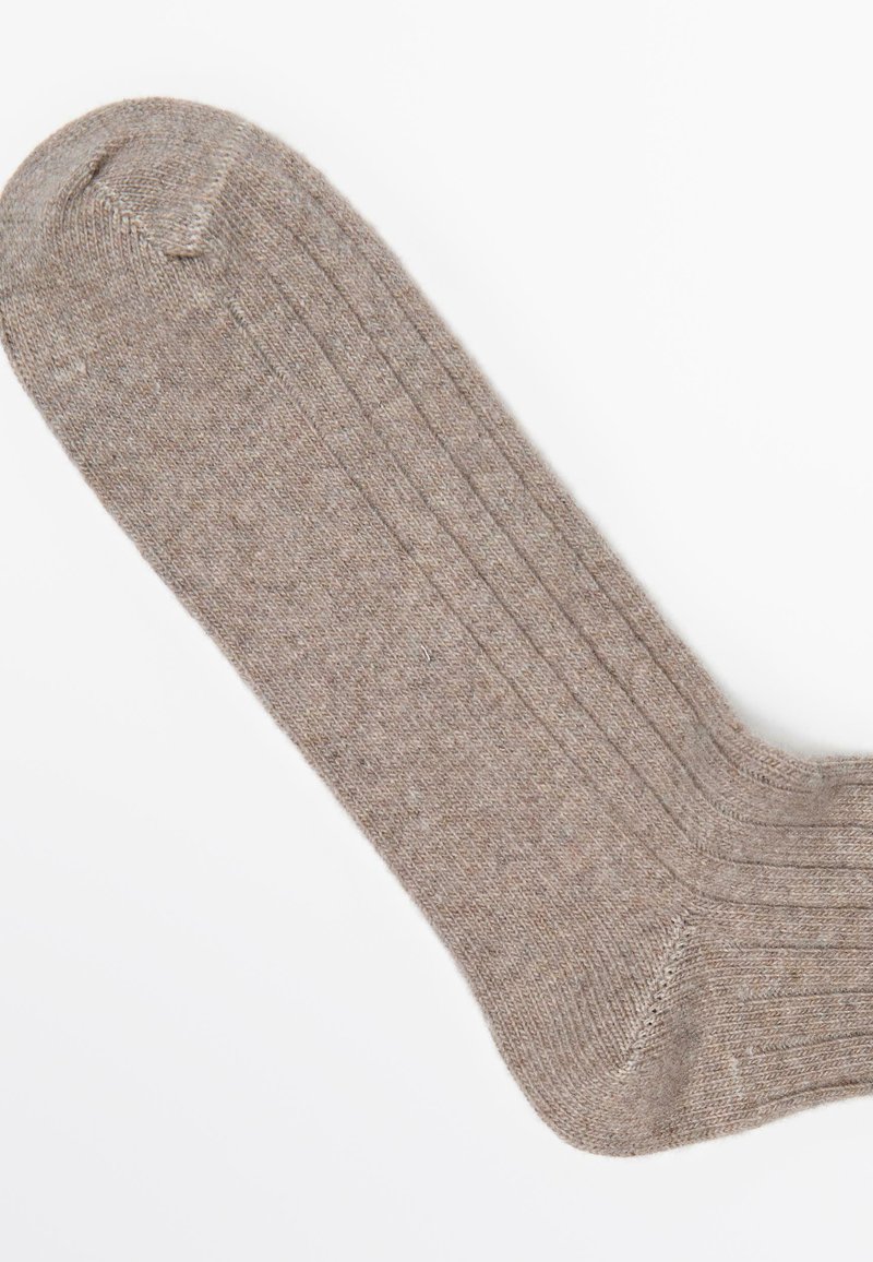 Brąsocka z prążkowanym wzorem o miękkiej fakturze, z wzmocnionymi palcami i piętą, prezentująca klasyczny design i gładkie wykończenie.