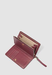 Portafoglio viola in pelle aperto che mostra più fessure per carte, un compartimento con bottone e una sezione con zip con fodera beige e cinturino da polso.