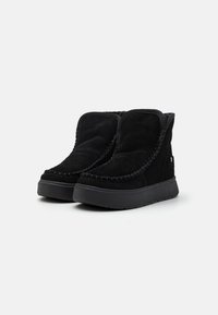 Schwarze Wildleder-Stiefeletten mit runder Zehenpartie, gepolstertem Kragen und dekorativen Nähten entlang der Kanten. Gummisohle mit rutschfester Textur.