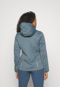 Women's hooded jacket in dark gray, made of textured fabric. Features side pockets and reflective accents. Back view shows adjustable hood.