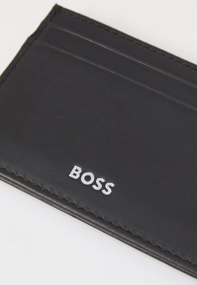 Porte-cartes en cuir noir avec plusieurs fentes ; arbore un logo "BOSS" en relief argenté ; texture lisse avec un bord cousu.