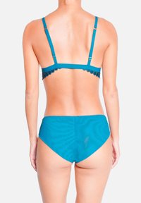 Ensemble bikini teal comprenant un bralette à bordure en dentelle avec des bretelles réglables et un bas taille haute. Texture lisse et couleur unie.