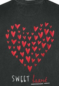 Čierna tkanina s červenými vyšívanými srdci rôznych veľkostí vytvárajúcimi tvar srdca, doplnená textom "SWEET heart" v bielej a červenej farbe.