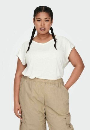 T-shirt blanc à manches courtes en V associé à un pantalon cargo beige clair avec poches latérales, texture lisse et coupe décontractée.