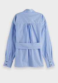 Lichtblauw, gestreept shirt met lange mouwen, een rugplooi en een strikdetail in de taille. Voorzien van knoopjes bij de manchetten en een klassieke kraagontwerp.