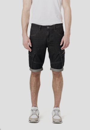 Dunkelblaue Denim-Cargoshorts mit hochgekrempelten Saum, mehreren Taschen und dezenten Strukturlinien. Kombiniert mit einem schlichten weißen T-Shirt und Sneakers.