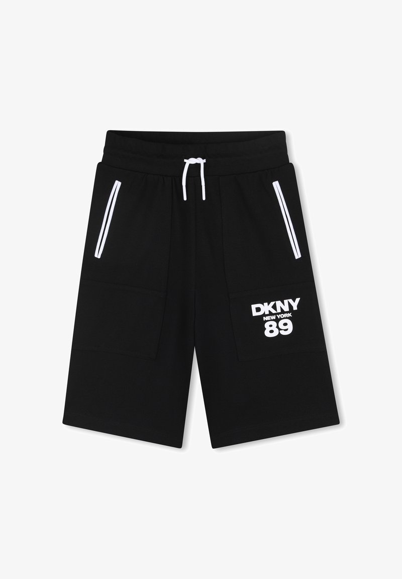 Shorts noirs mi-genoux avec cordon de serrage blanc, détails de fermeture éclair blanche sur les poches, et "DKNY New York 89" imprimé sur la poche de la jambe droite.
