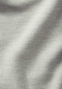 Lys gr å strikket stof med en glat tekstur og fin vævning, med subtile variationer i tone og skygge hele vejen igennem.