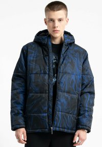 Padded jacket w czarnym i niebieskim wzorem wiru, z kapturem, zapinany na zamek z przodu i bocznymi kieszeniami. Teksturowana tkanina o pikowanym wzorze.