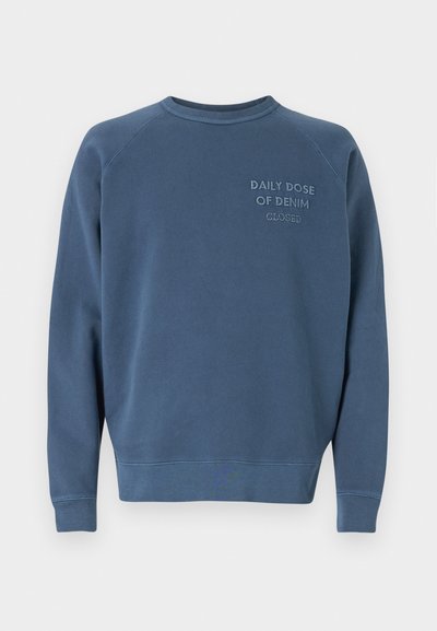 Sweatshirt albastru cu guler rotund, fabricat dintr-un amestec de bumbac. Dispune de manșete și tiv ribborșate, cu text brodat pe piept. Design simplu.