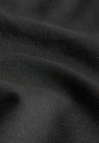 Fekete szövet sima, enyhén texturált felülettel. Az anyag puhanak és rugalmasnak tűnik, egységes szövési mintával.