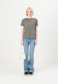 Gray cotton t-shirt with short sleeves, paired with light blue flared jeans. Accessories include a white handbag and black shoes.