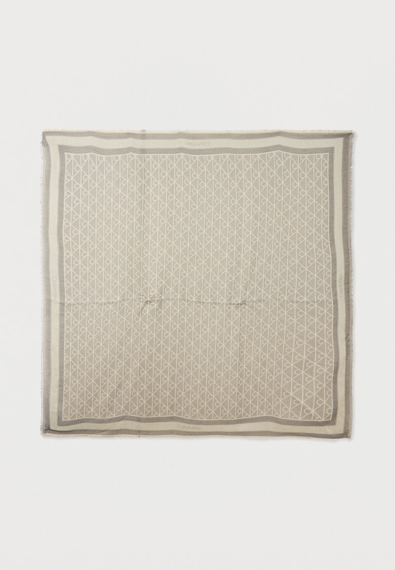 Μπεζ τετράγωνο φουλάρι με γεωμετρικό μοτίβο ρόμβου και βρόχου και ανοιχτό γκρι περιγράμματα, με διακριτικά λογότυπα της μάρκας στις άκρες.