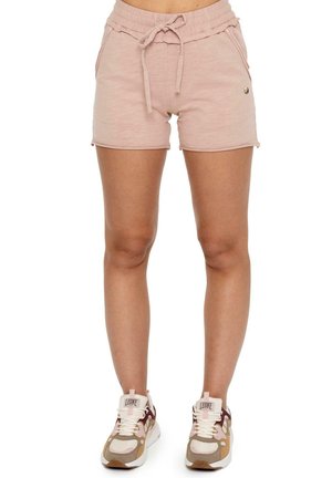 Image recadrée d’un mannequin portant un short rose pâle à cordon et des baskets beiges, blanches et bordeaux sur fond blanc.