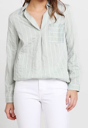 Camicia verde chiaro a maniche lunghe con strisce verticali bianche, collo con risvolto e taschino singolo sul petto, realizzata in tessuto strutturato.