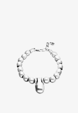 Bracelet en perles d'argent avec un petit charm en forme de gant de boxe et un fermoir avec une étiquette attachée.