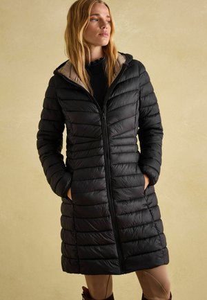 Black puffer coat with hood, featuring quilted texture, front zipper closure, and two side pockets. Interior in contrasting beige.