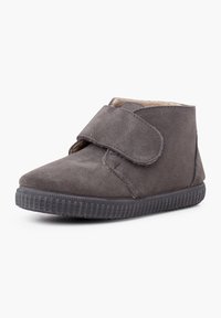 Stivale alla caviglia in camoscio grigio con cinturino in Velcro, suola in gomma e dettagli testurizzati. Fodera interna morbida per comfort e supporto.