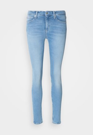 Világoskék, vékony szabású farmernadrág, közepes derékmagassággal, elöl zsebekkel, övhurkokkal és sima felülettel.