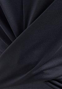 Mörk marinblått tyg med diagonala plisseringar, som har en slät yta och subtil glans. Materialet verkar vara töjbart och strukturerat.