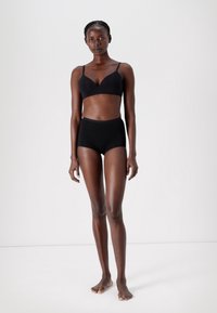 Black lingerie set featuring a seamless, lightly padded bra with adjustable straps and high-waisted, stretchy brief bottoms in a smooth fabric.
