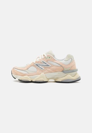 Light peach and cream sneaker with mesh, suede panels, and grey accents. Thick sole with black rubber outsole. Laced design with logo on side.