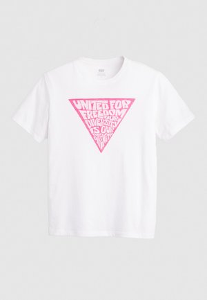 Valge puuvillane T-särk, millel on suur roosa kolmnurkne graafika ja tekst "Ühinenud Vabaduse Nimel, Mitmekesisus on Meie Jõud." Lühikesed varrukad.