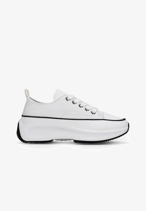 Baskets en toile blanches avec une semelle arrondie et surélevée, présentant des accents noirs et cinq œillets pour les lacets. Texture lisse avec des éléments de design minimaux.