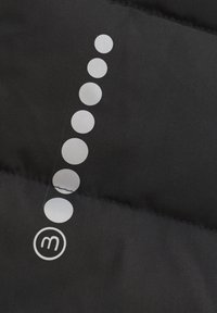 Czarna kurtka puchowa z tkaniny, z pionowym rzędem sześciu okrągłych srebrnych wzorów oraz małym okrągłym logo z literą "m."