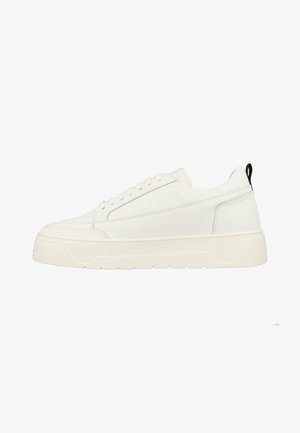White leather sneakers with a textured side panel, thick rubber sole, flat laces, and a contrasting black pull tab at the heel.